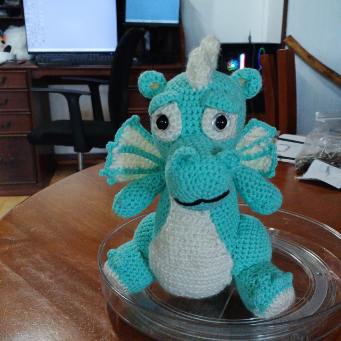 Squeakz, a teal and cream crocheted dragon amigurumi